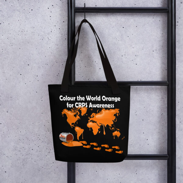 Black eco friendly tote bag with Colour the World Orange for CRPS Awareness in white print and an orange flat world map dripping orange paint, plus a spilled orange paint tin with footprints